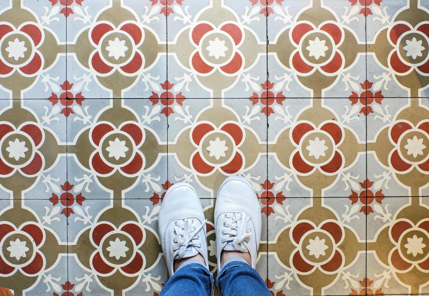 Top view selfie of feet in sneakers shoes on the vintage seamless floor background with copy space photo