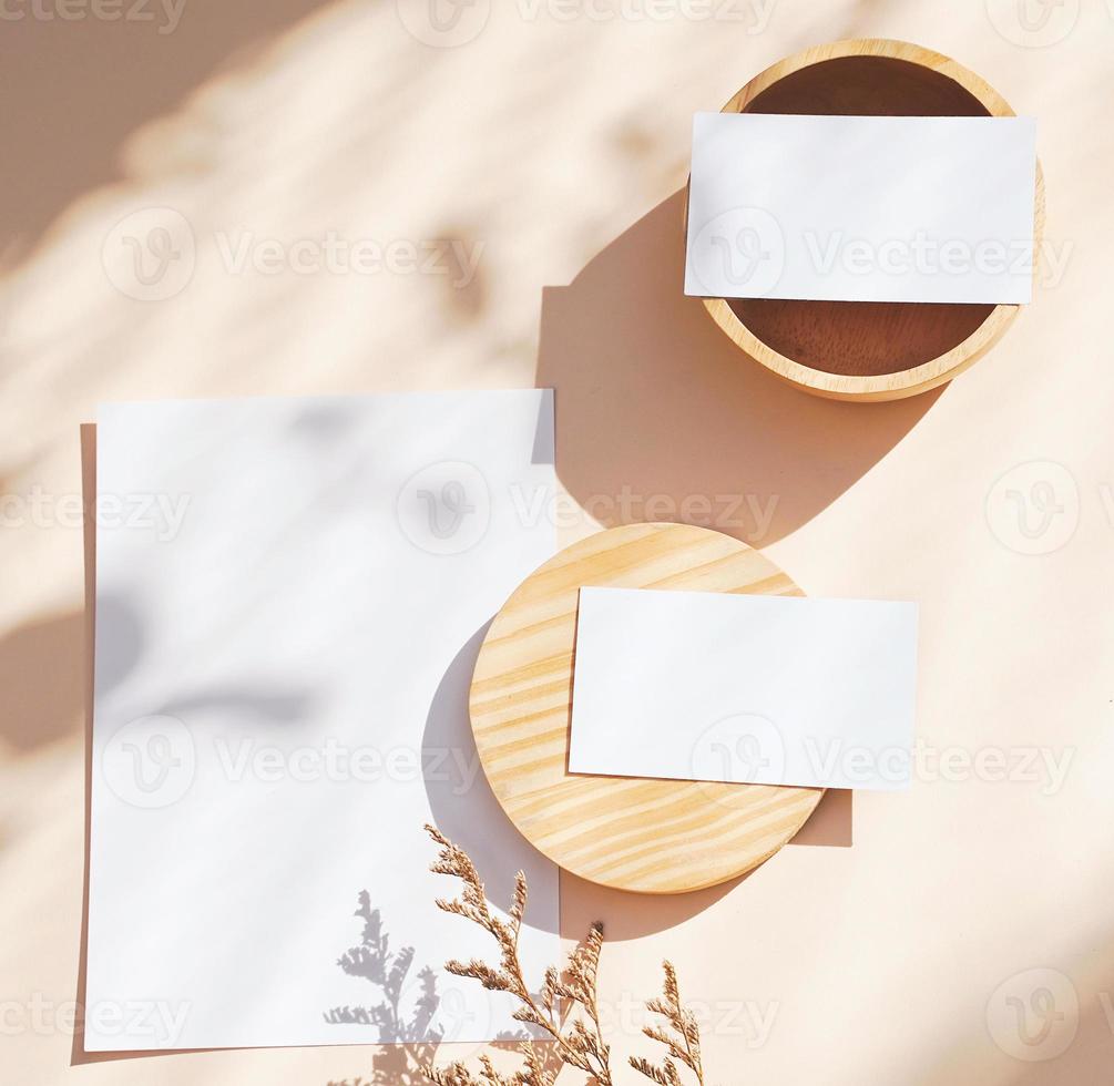 Flat lay of branding identity business name card on yellow background with flower and wooden container, light and shadow shape, minimal concept for design photo