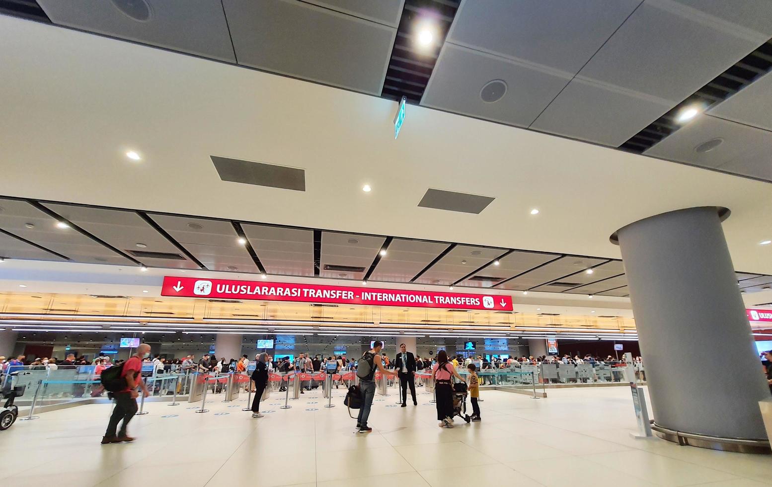 Istanbul, Turkey on July 2022. Several tourists are queuing for passport checking at the passport control counter, both local and international tourists. photo