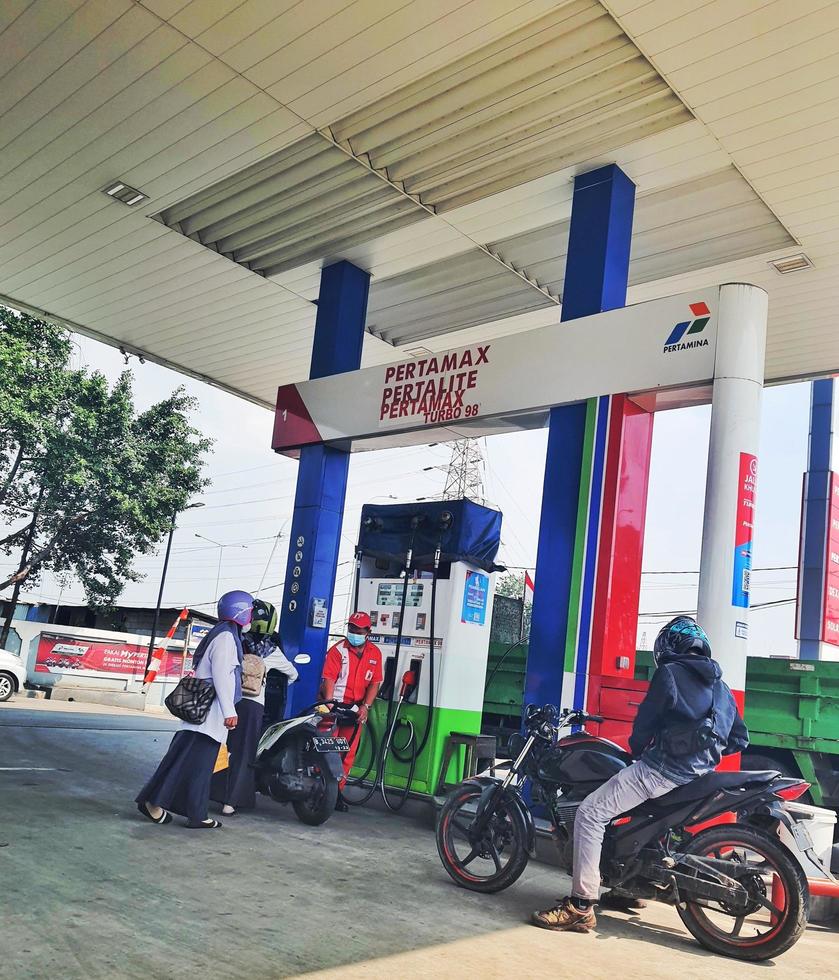 West Java, Indonesia on July 2022. Motorcyclists are queuing to refuel their motorbikes at a gas station. photo