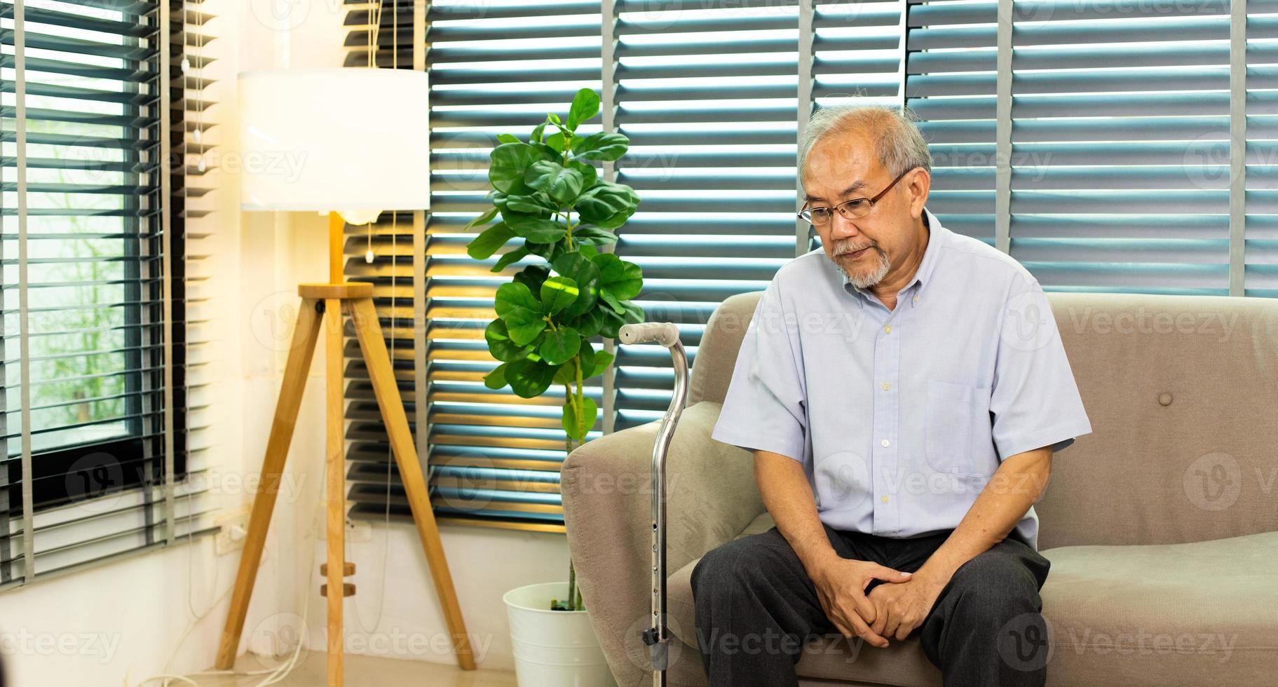Grandfather unhappy health from pain Knee injury. Senior Elderly man has problem on joint knee leg and suffer ache health care problem when sitting and need walker staff to support help, copy space photo