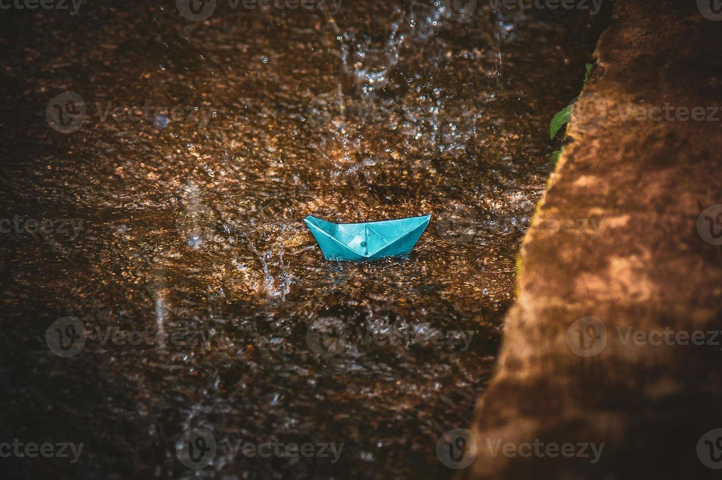 Origami paper boat in the rain photo