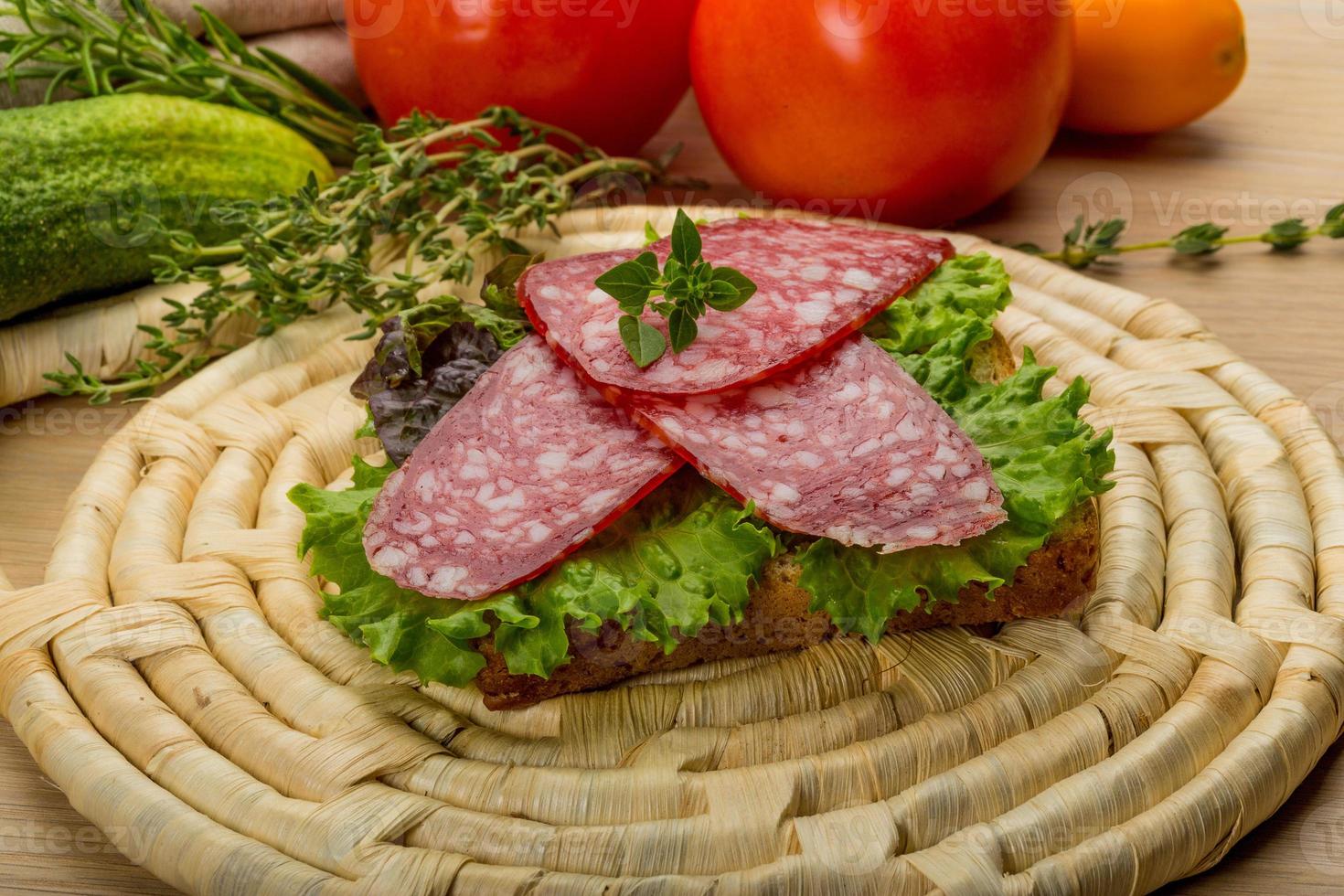 salchichas de salami sobre tablero de madera y fondo de madera foto