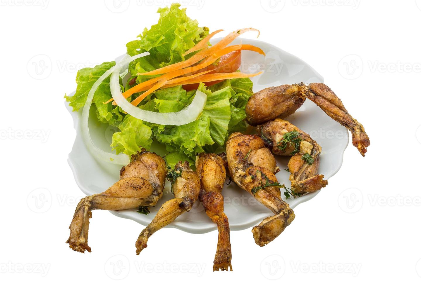 Grilled frog legs on the plate and white background photo