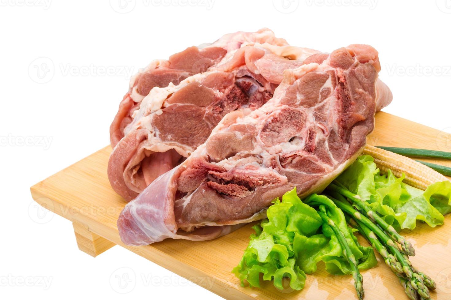 Raw lamb on wooden board and white background photo