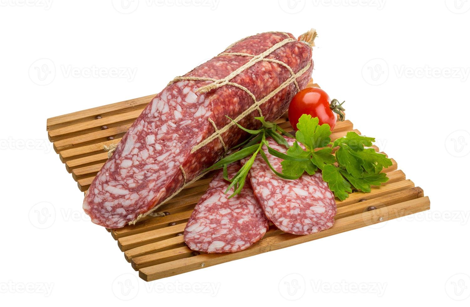 Salami on wooden board and white background photo