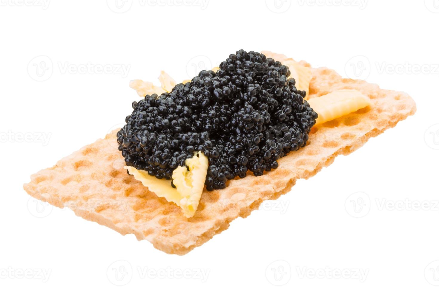 Toast with black caviar on white background photo