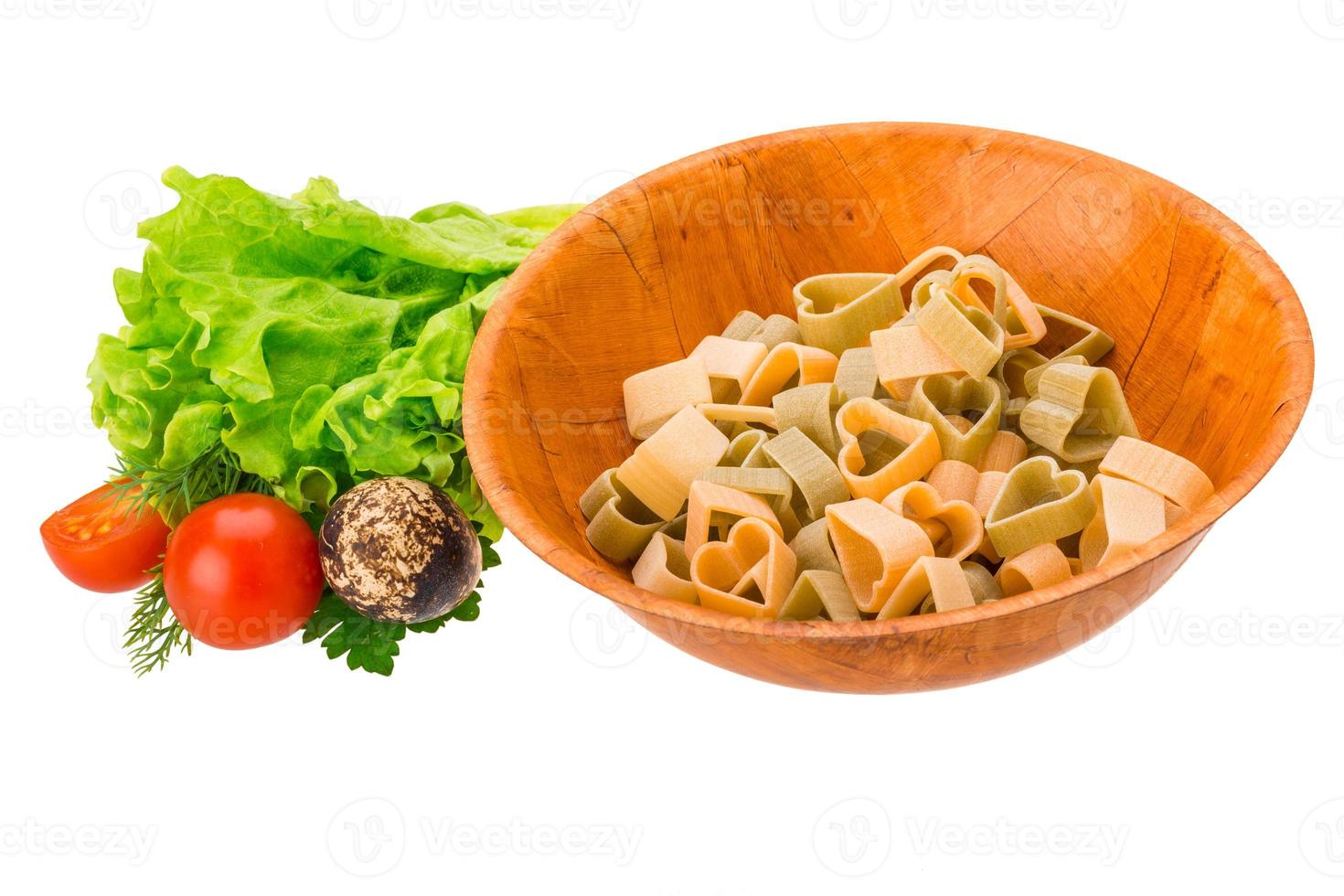 Raw pasta in a bowl on white background photo