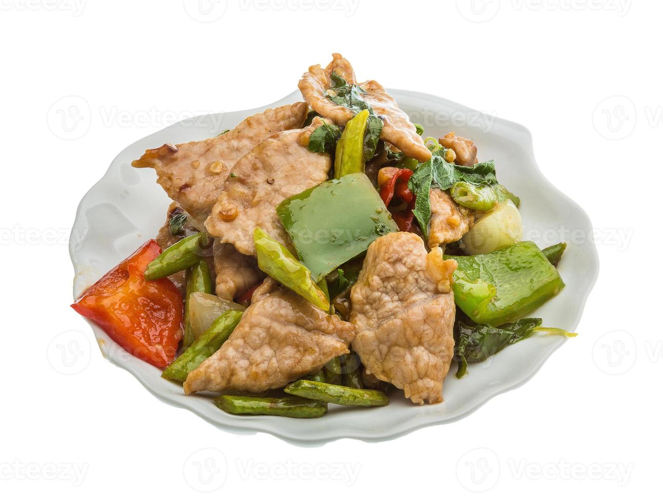 Pork with vegetables on the plate and white background photo