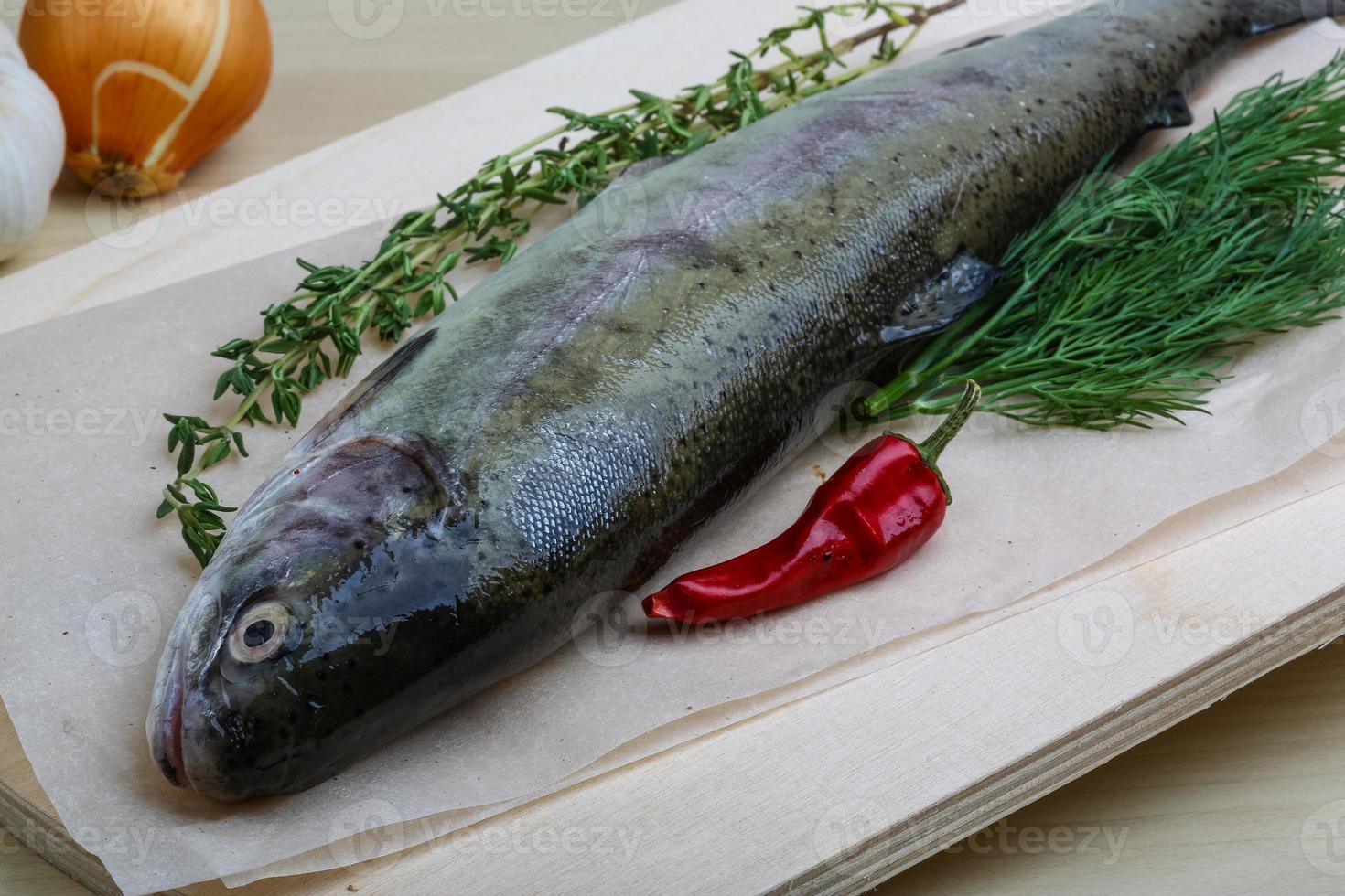 Raw trout on wooden board and wooden background photo