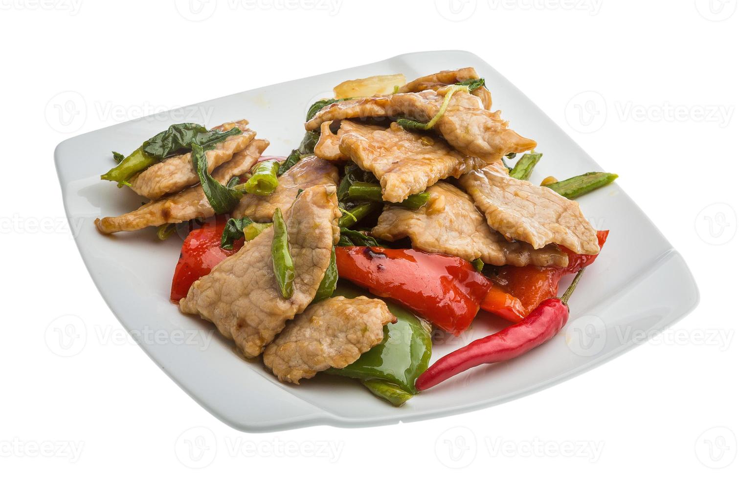 Pork with vegetables on the plate and white background photo