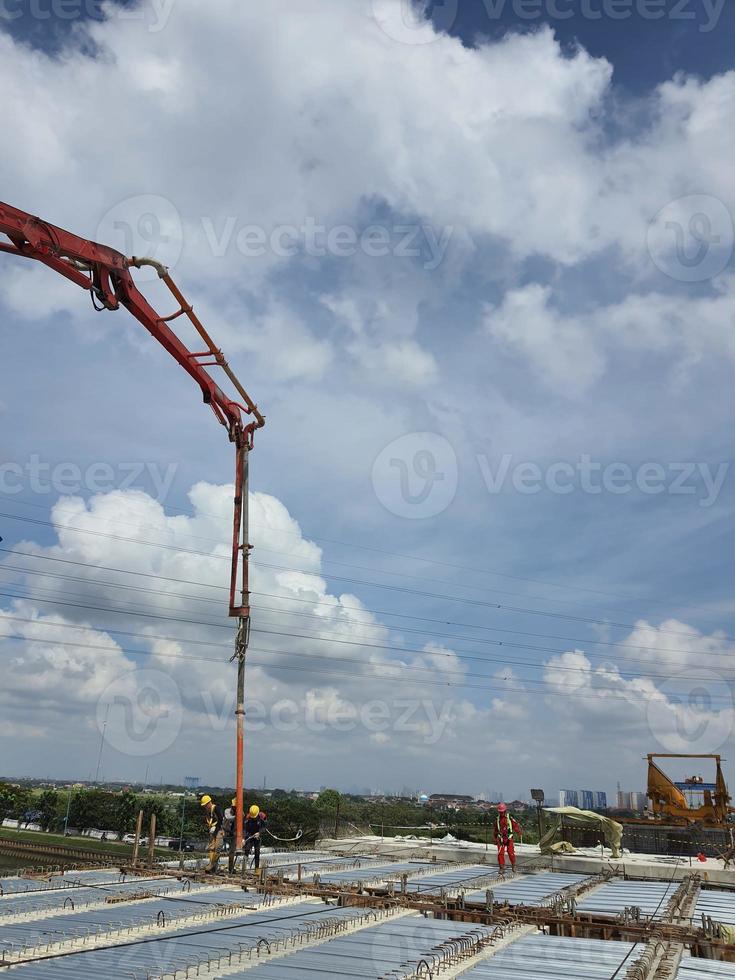 This is a process of casting concrete using a concrete pump to reach casting locations that are far away. photo