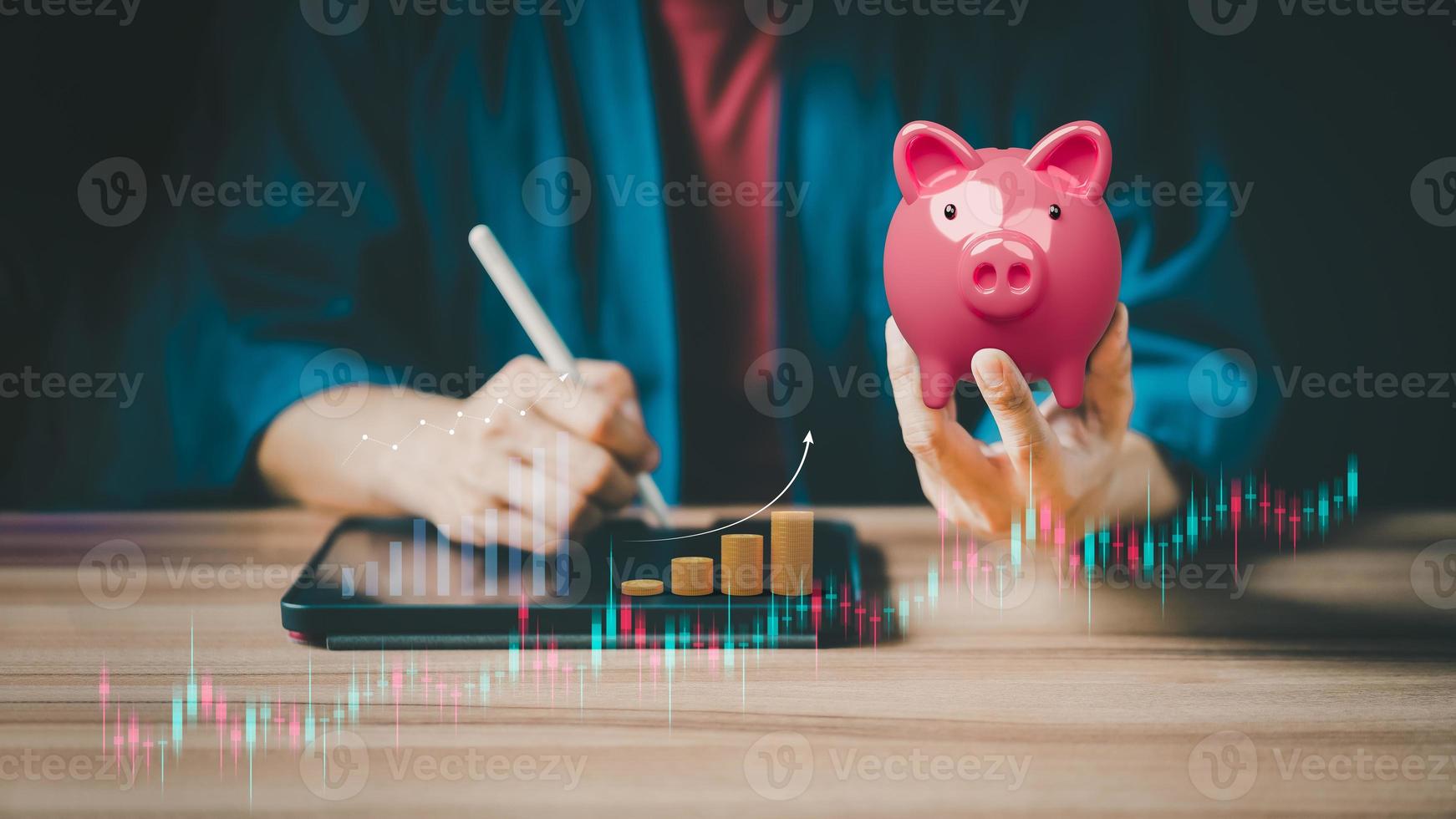 Closeup image of a pink piggy bank and taking note on the tablet for planning, saving money wealth and financial concept. Business online, finance and investment. photo