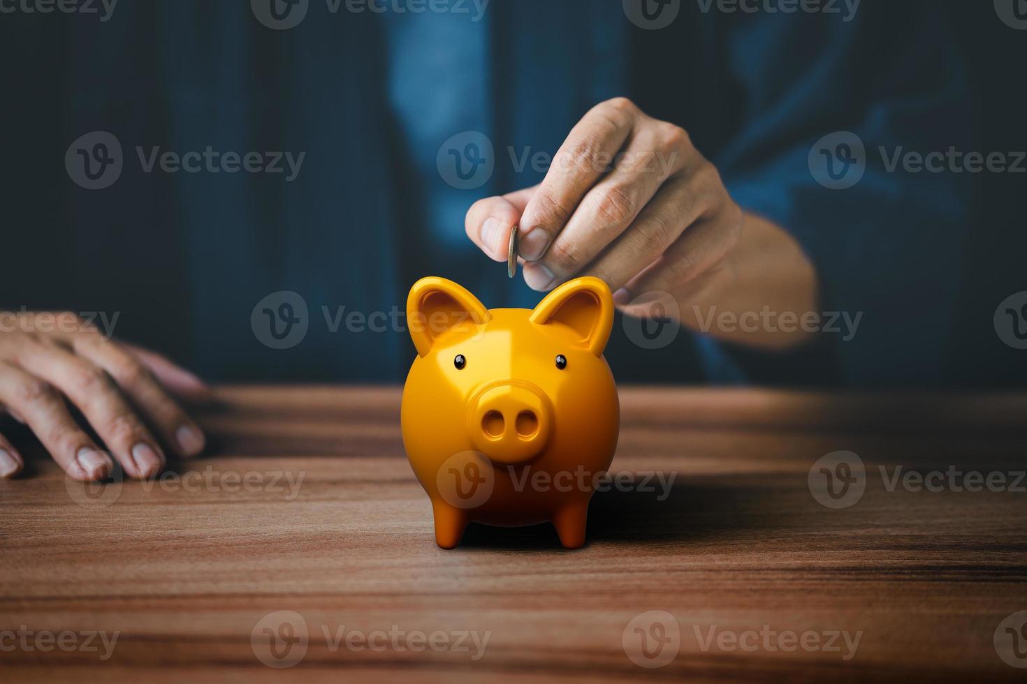 Man putting coin into golden piggy bank for saving money concept, business finance and investment. photo