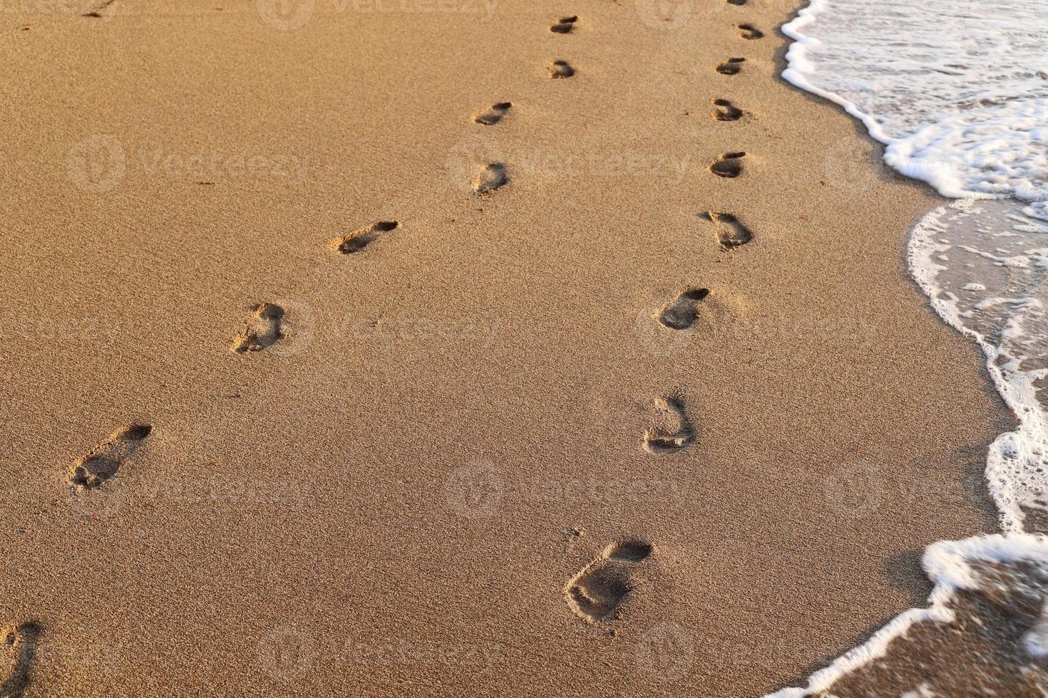 Footprints in the sand on the shores of the Mediterranean Sea. photo