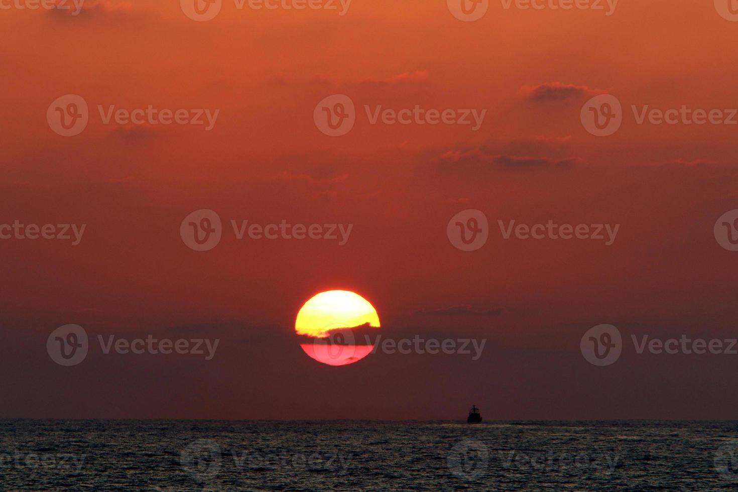 The sun sets below the horizon on the Mediterranean Sea in northern Israel. photo