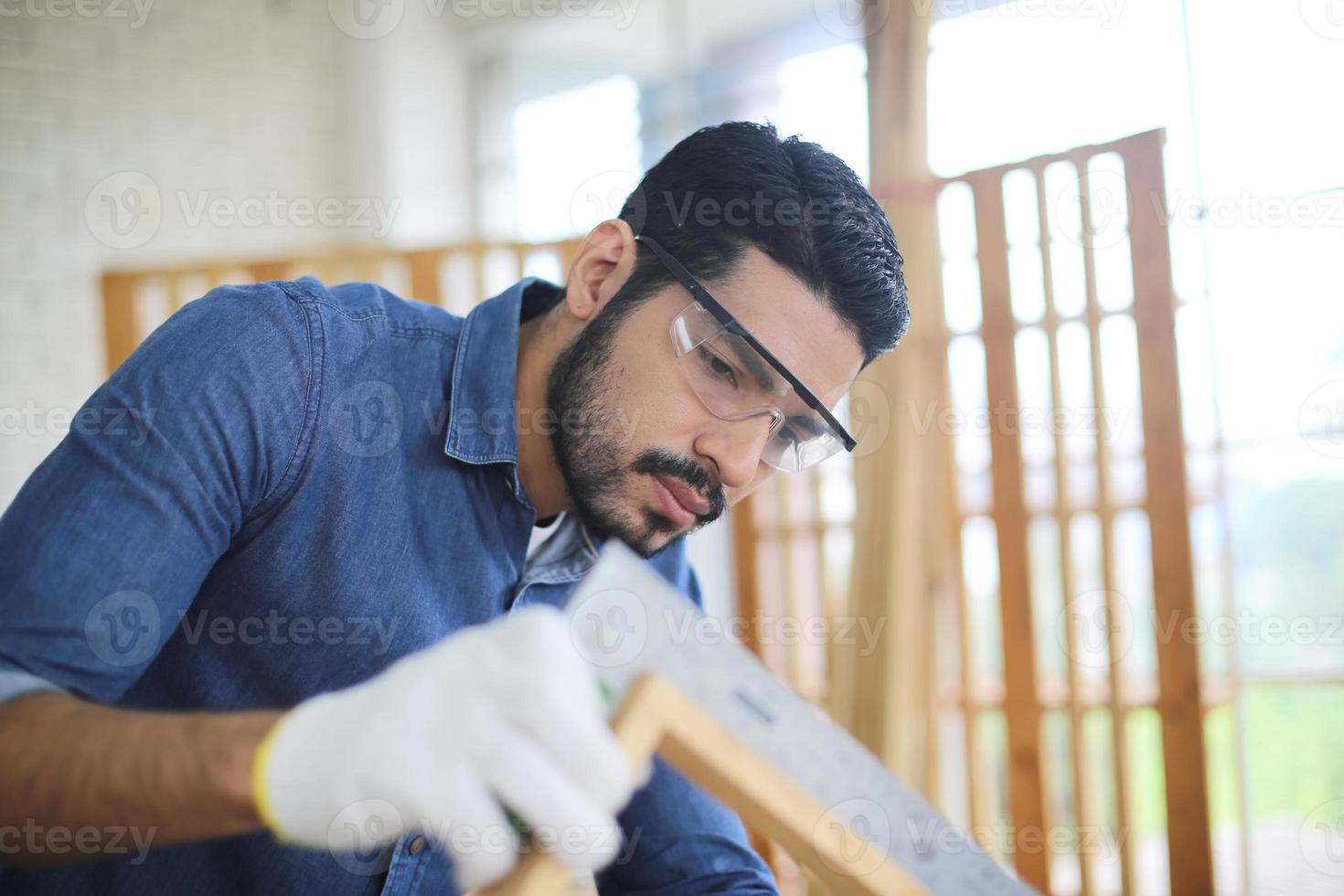 Carpenter grinding joinery product with carvings, finishing woodwork at the carpentry manufacturing photo