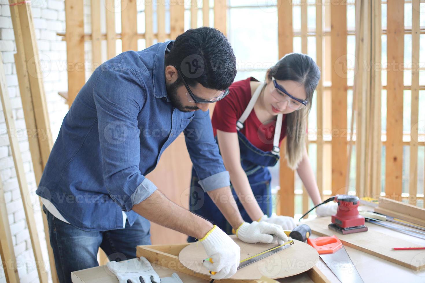 Carpenter grinding joinery product with carvings, finishing woodwork at the carpentry manufacturing photo