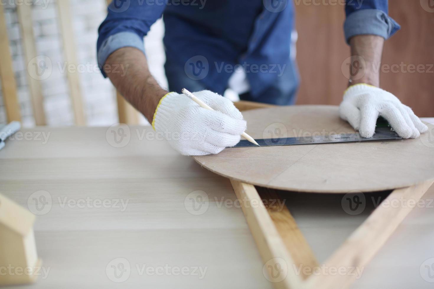 Carpenter grinding joinery product with carvings, finishing woodwork at the carpentry manufacturing photo