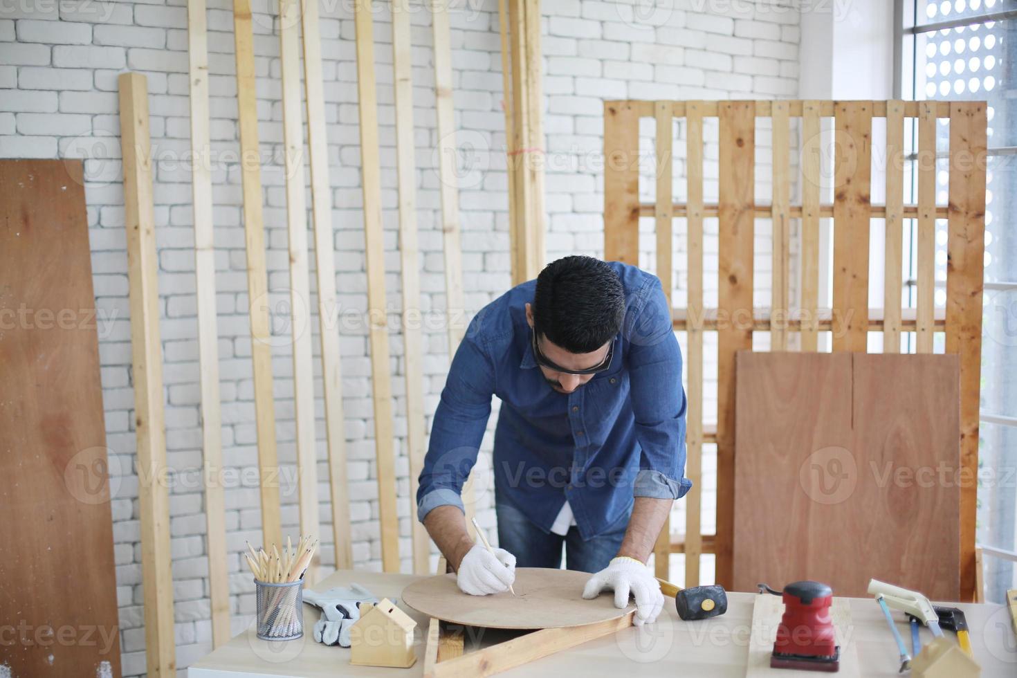 Carpenter grinding joinery product with carvings, finishing woodwork at the carpentry manufacturing photo