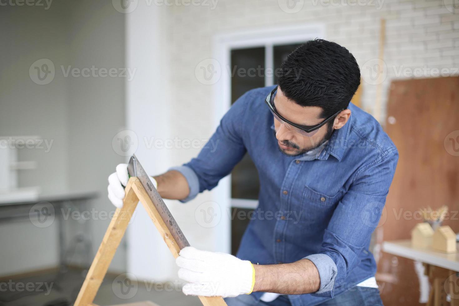 Carpenter grinding joinery product with carvings, finishing woodwork at the carpentry manufacturing photo