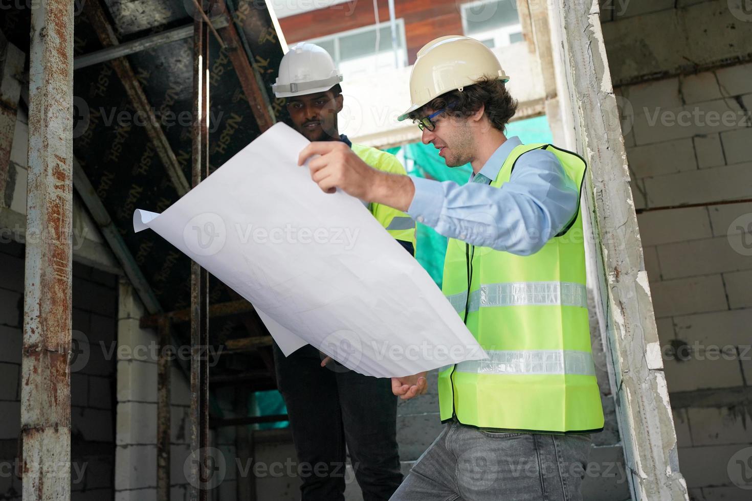Architect and construction engineer or surveyor discussion plans and blueprints photo