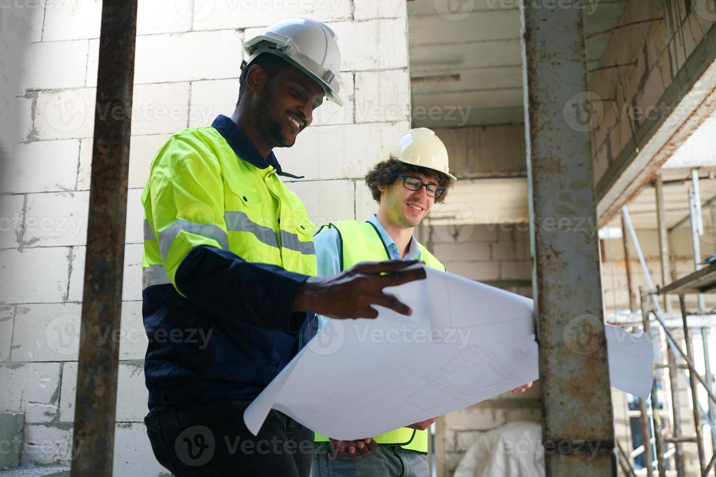 Arquitecto e ingeniero de construcción o agrimensor debaten planes y planos foto