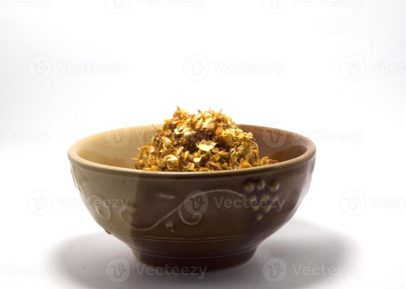 Fried garlic for topping and adding flavor and decorating food to make it more appetizing. It is a popular spice and herb that people around the world consume on a white background in a cup. photo