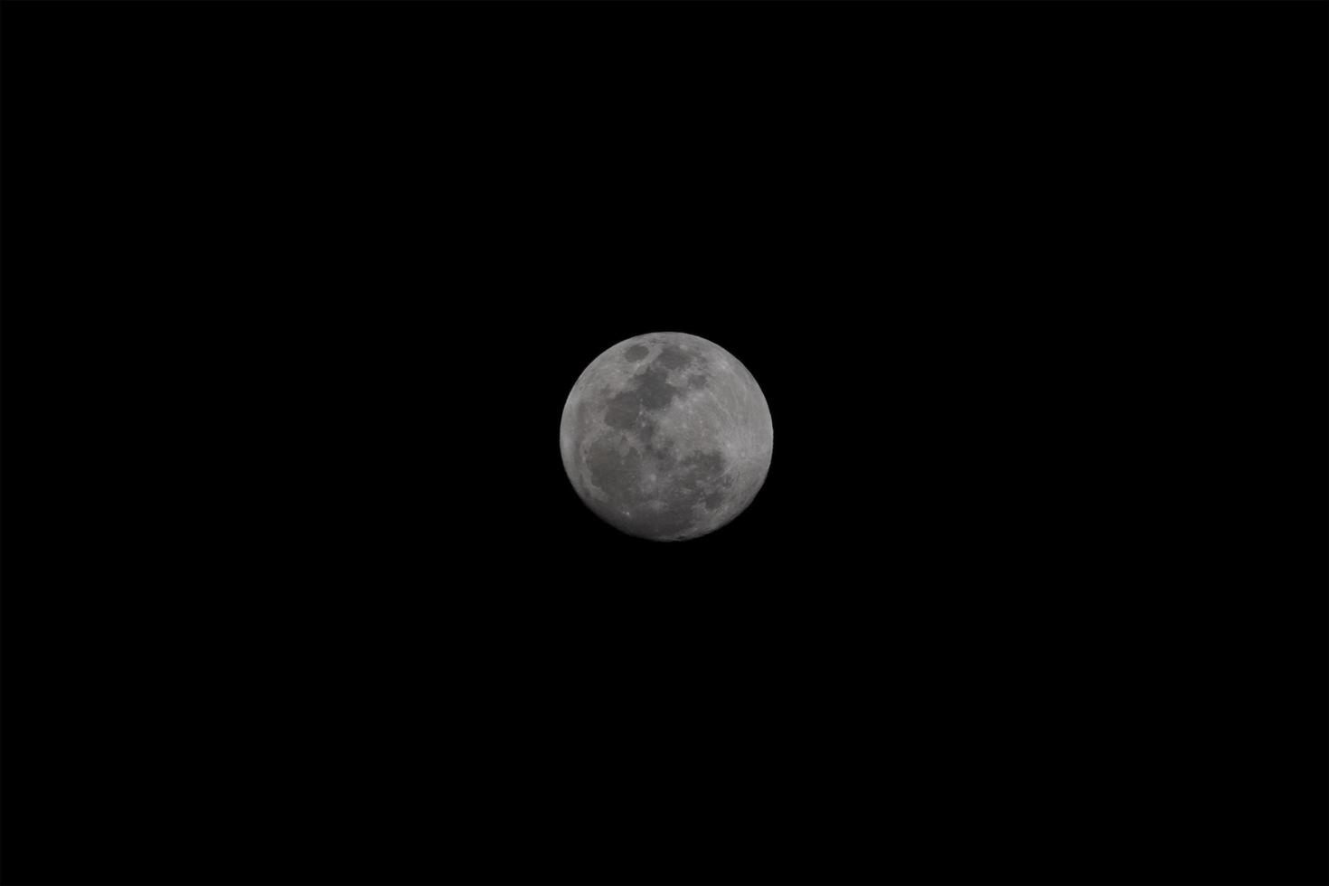 Full moon over dark black sky at night. photo