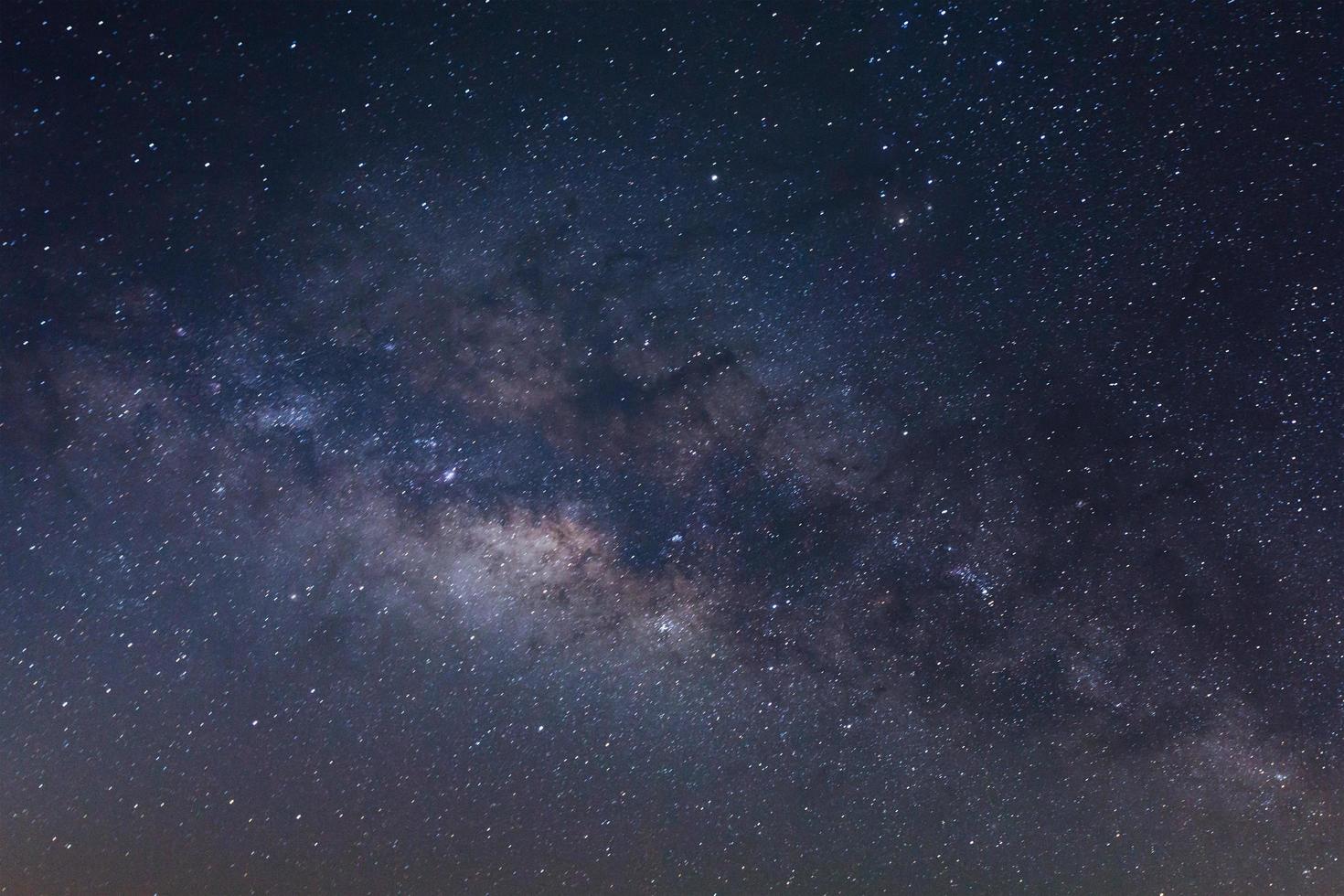 el centro de la galaxia de la vía láctea con estrellas y polvo espacial en el universo, fotografía de larga exposición, con grano foto