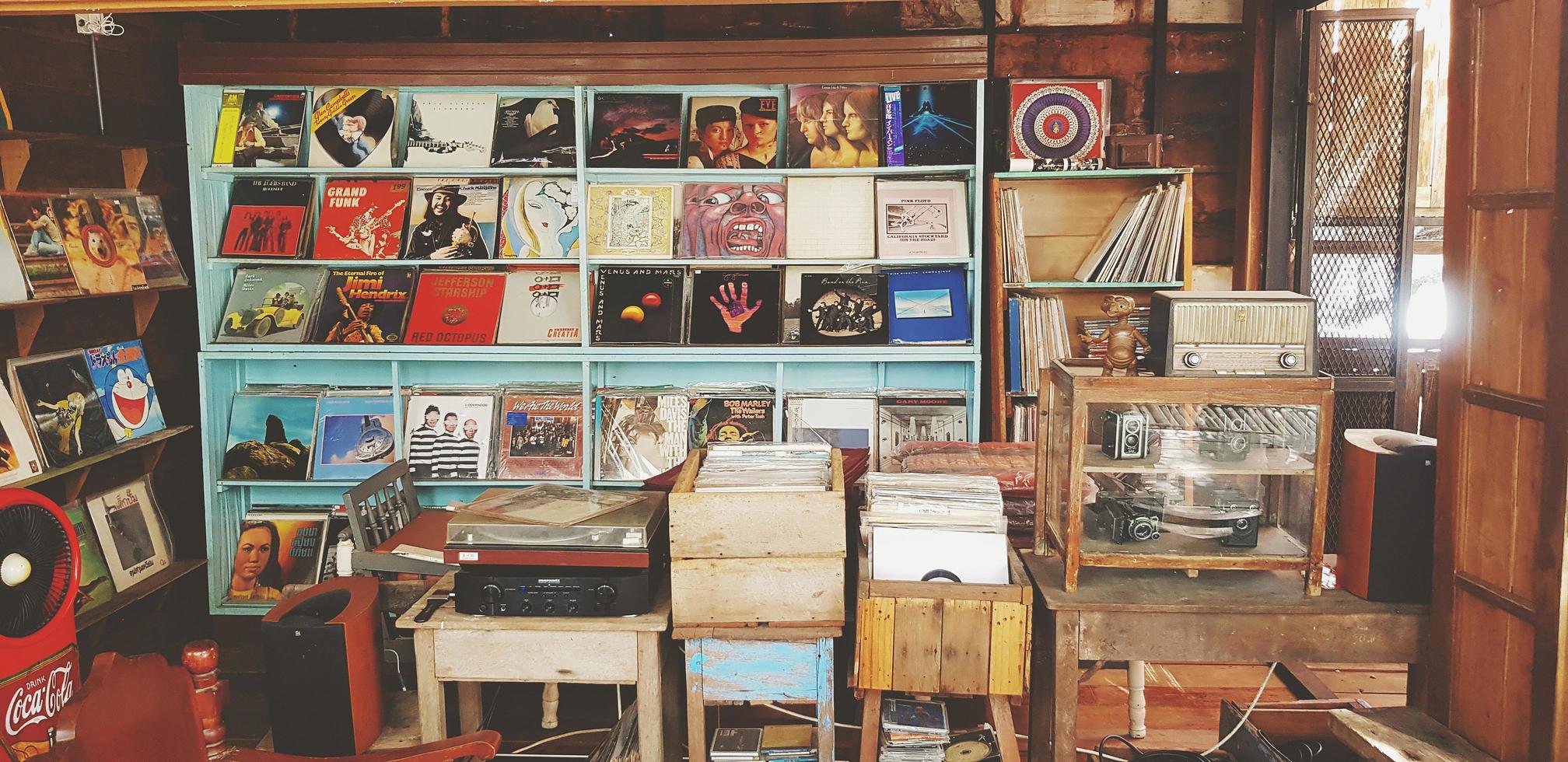 Samut Sakhon Thailand  July 15 2022 Many record or dish put on wooden shelf for sale. Collection of Vintage object and classic camera in glass cabinet in vintage tone. Music shop concept. photo