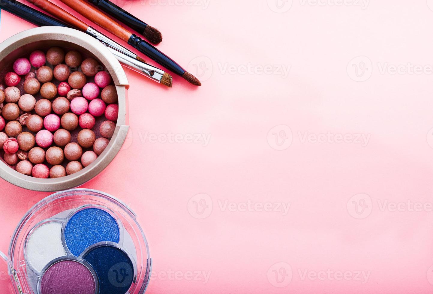 Frame of cosmetic accessories on pink background with copy space. Top view photo