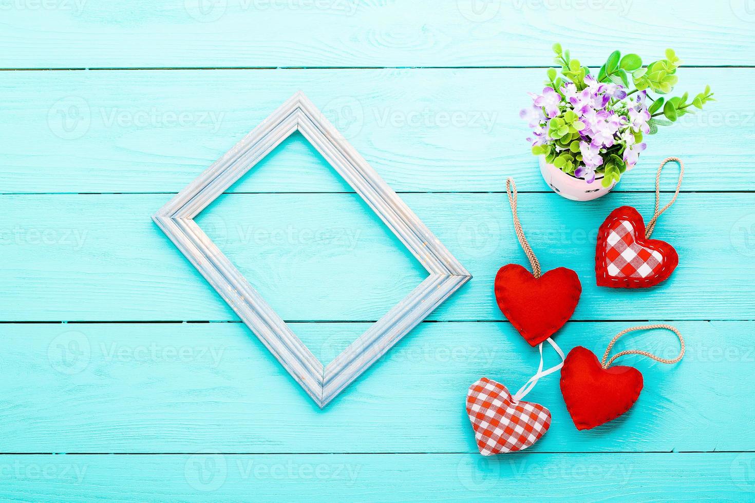 Valentines accessories and vase with flowers on blue wooden table. Top view photo