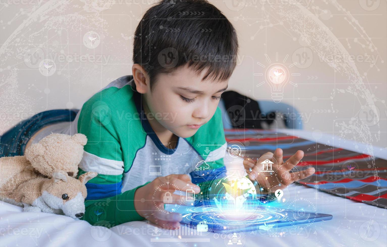 Kid using tablet research on internet about world population,Ecology or Environmental,School Boy doing online learning,Geography with Double exposure growth leaf on globe map photo