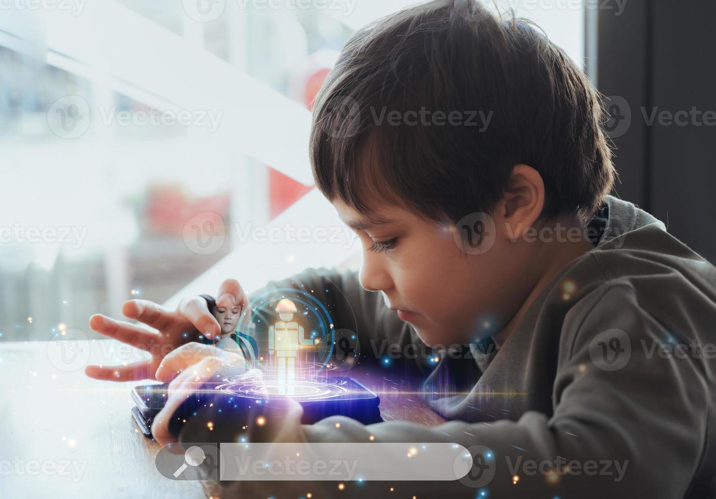 Kid building robot game on tablet with notification face icon pop up,Boy programming Robot on digital pad with double exposure screen web surfing,cyber diagram interface,Education technology photo