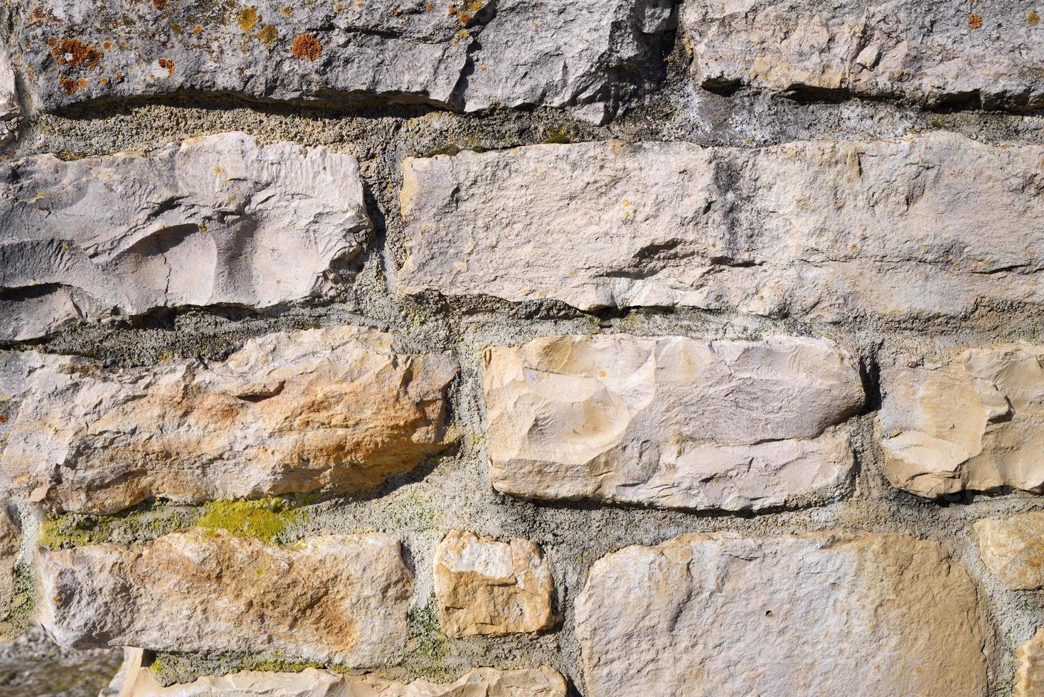 Background of a wall made of natural stones that have been machined and put on top of each other with mortar that is old. photo