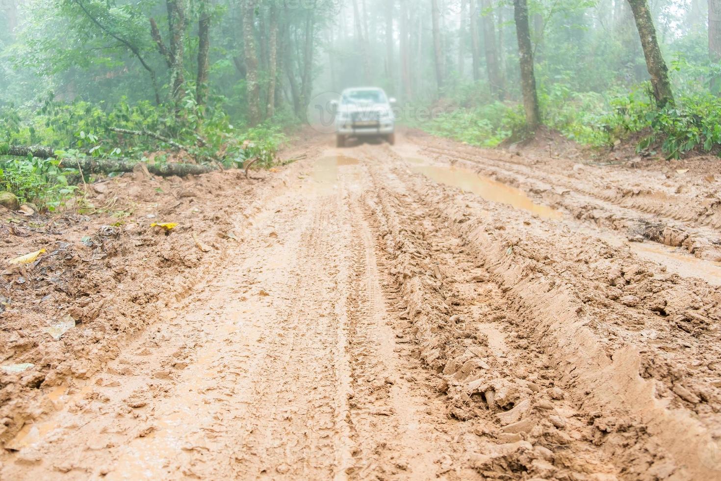 Wheel truck closeup in countryside landscape with muddy road. Extreme adventure driving 4x4 vehicles for transport or travel or off-road races in outdoor nature. 4wd tire automobile on dirt mountain. photo