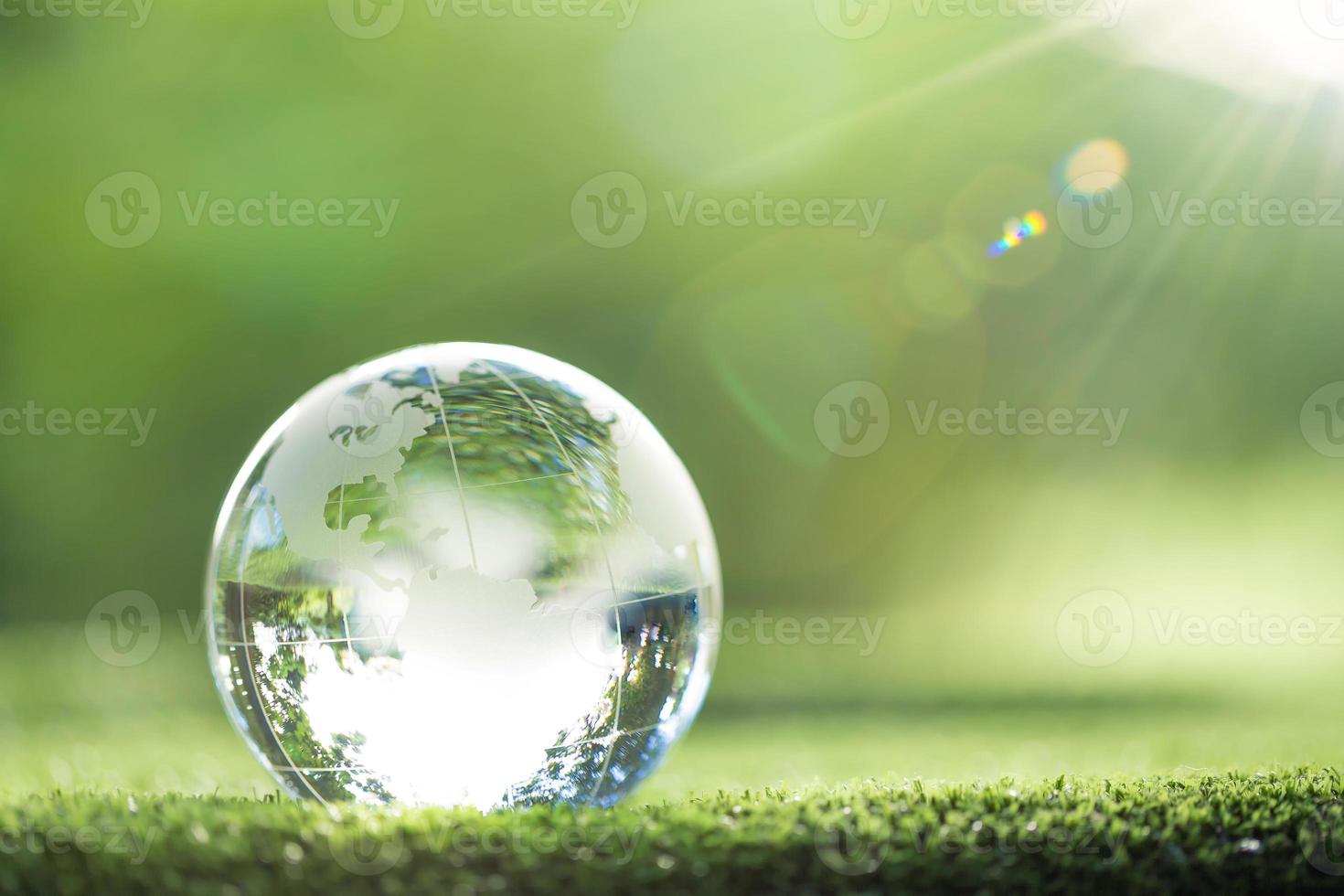 globo planeta cristal en bosque verde con luces de naturaleza bokeh. día Mundial del Medio Ambiente. concepto para la conservación del medio ambiente, proteger la ecología de la tierra y la vida ecológica con espacio de copia foto