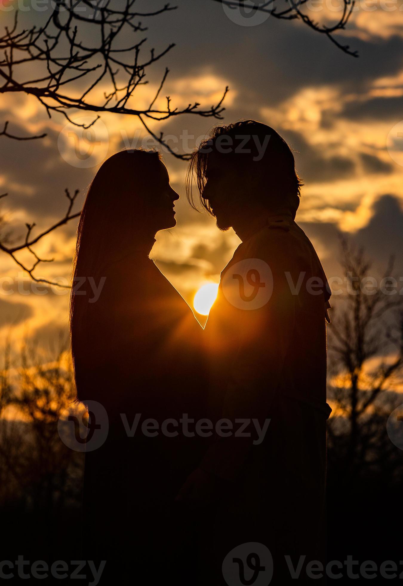 Silhouette of romantic couple in love, man and women in sunset sky