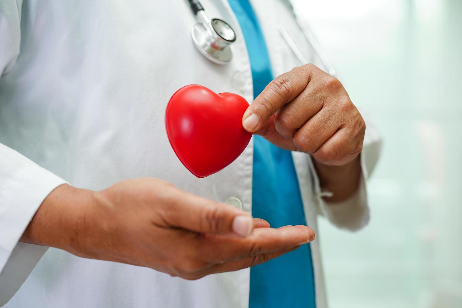 Asian woman doctor holding red heart for health in hospital. photo