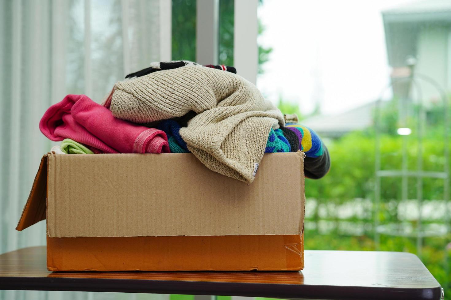 Clothes donations in cardboard box for volunteer. 11250588 Stock Photo