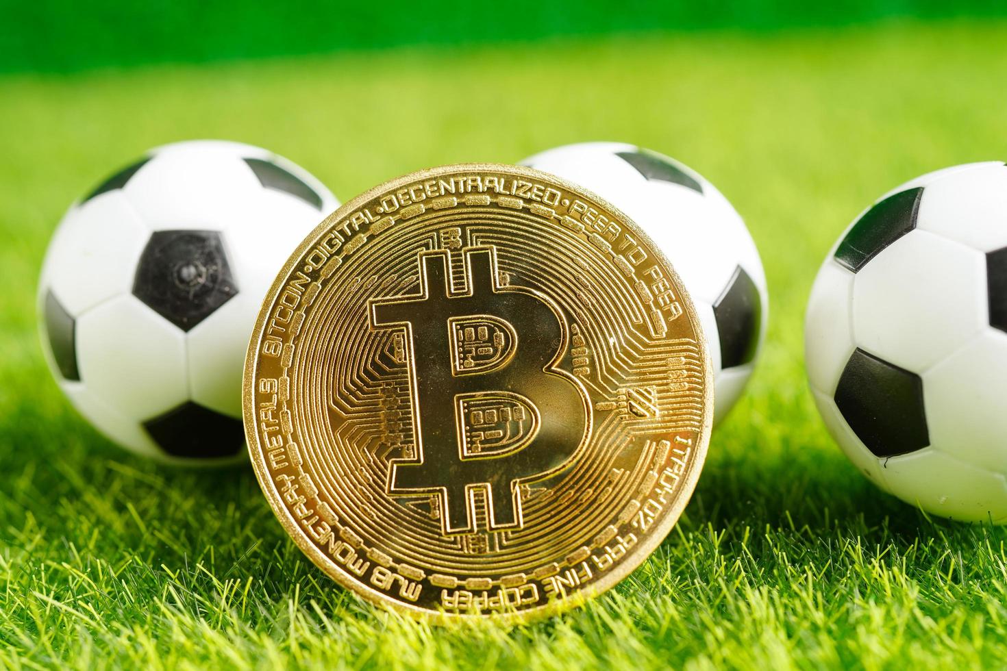 Gold bitcoin with soccer ball or football, cryptocurrency used in online sports betting. photo