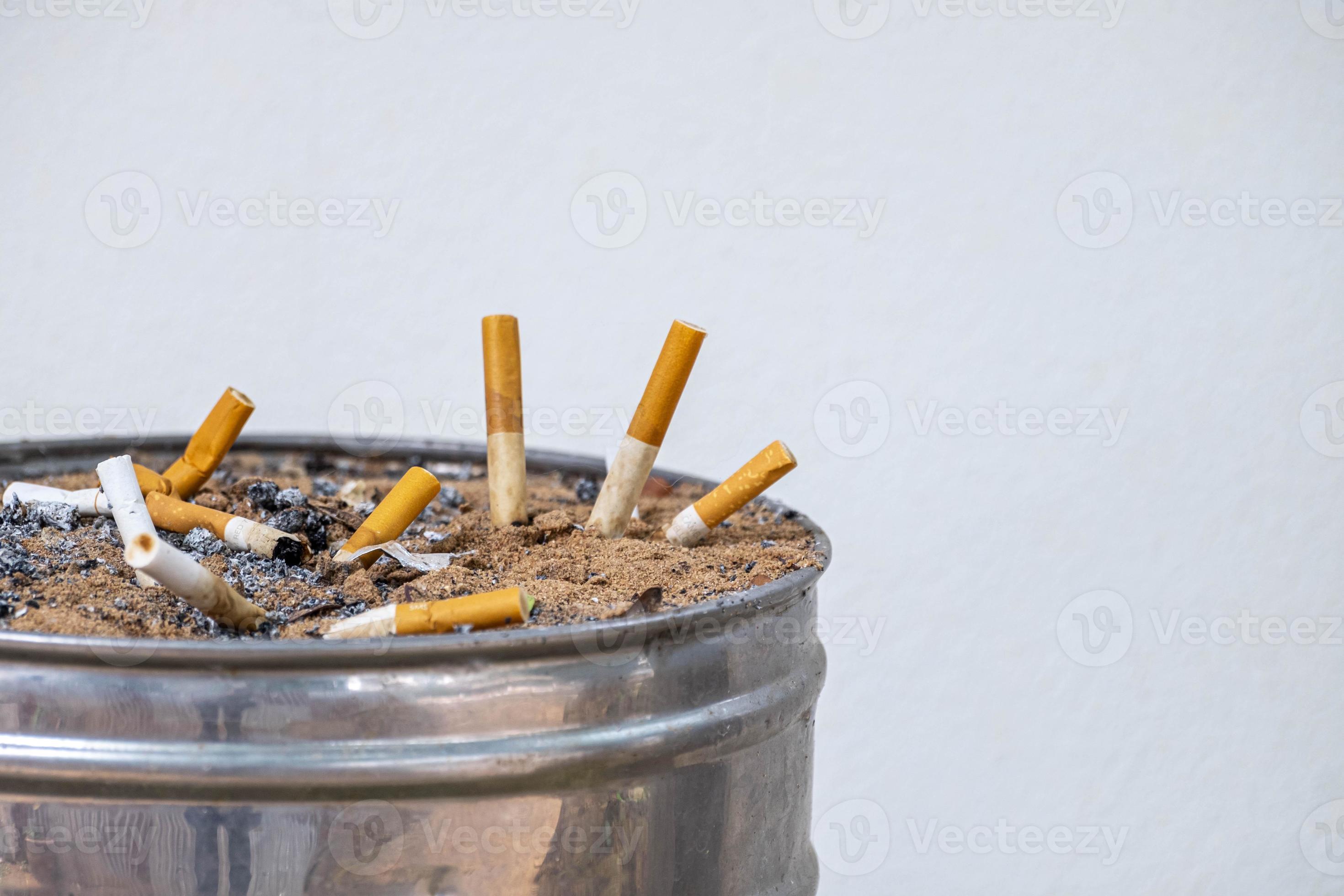 used cigarettes was left in the ashtray consisting of coarse sand and  aluminum material in a public smoking area and white wall 11252379 Stock  Photo at Vecteezy