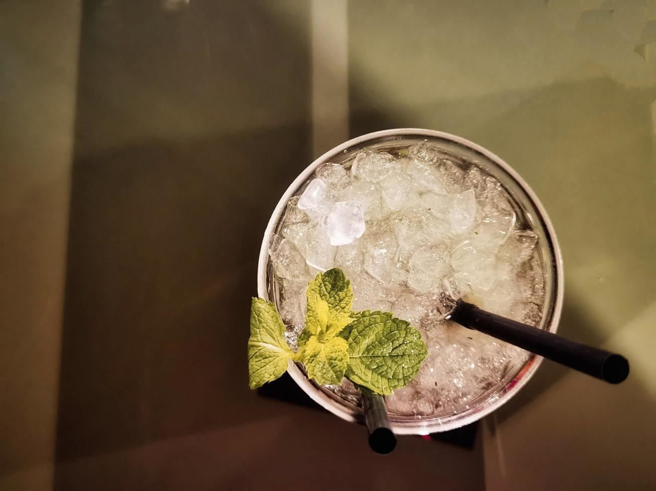 a glass of mojito with its toppings on a coffee table photo