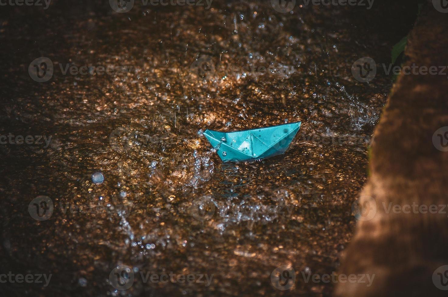 Origami paper boat in the rain photo