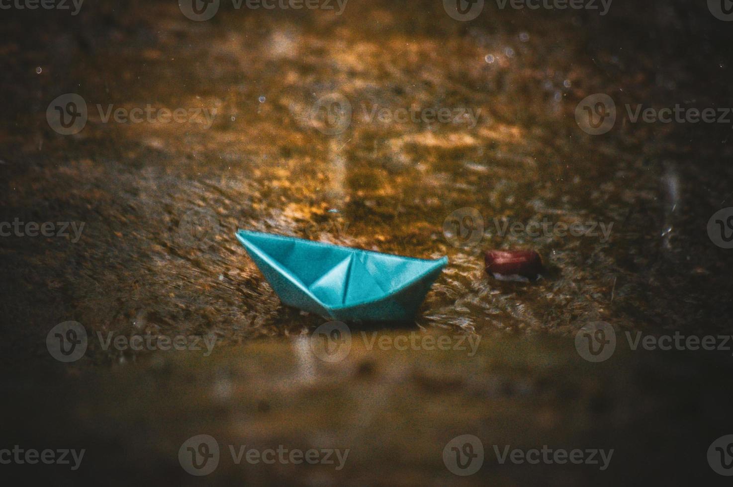 Origami paper boat in the rain photo