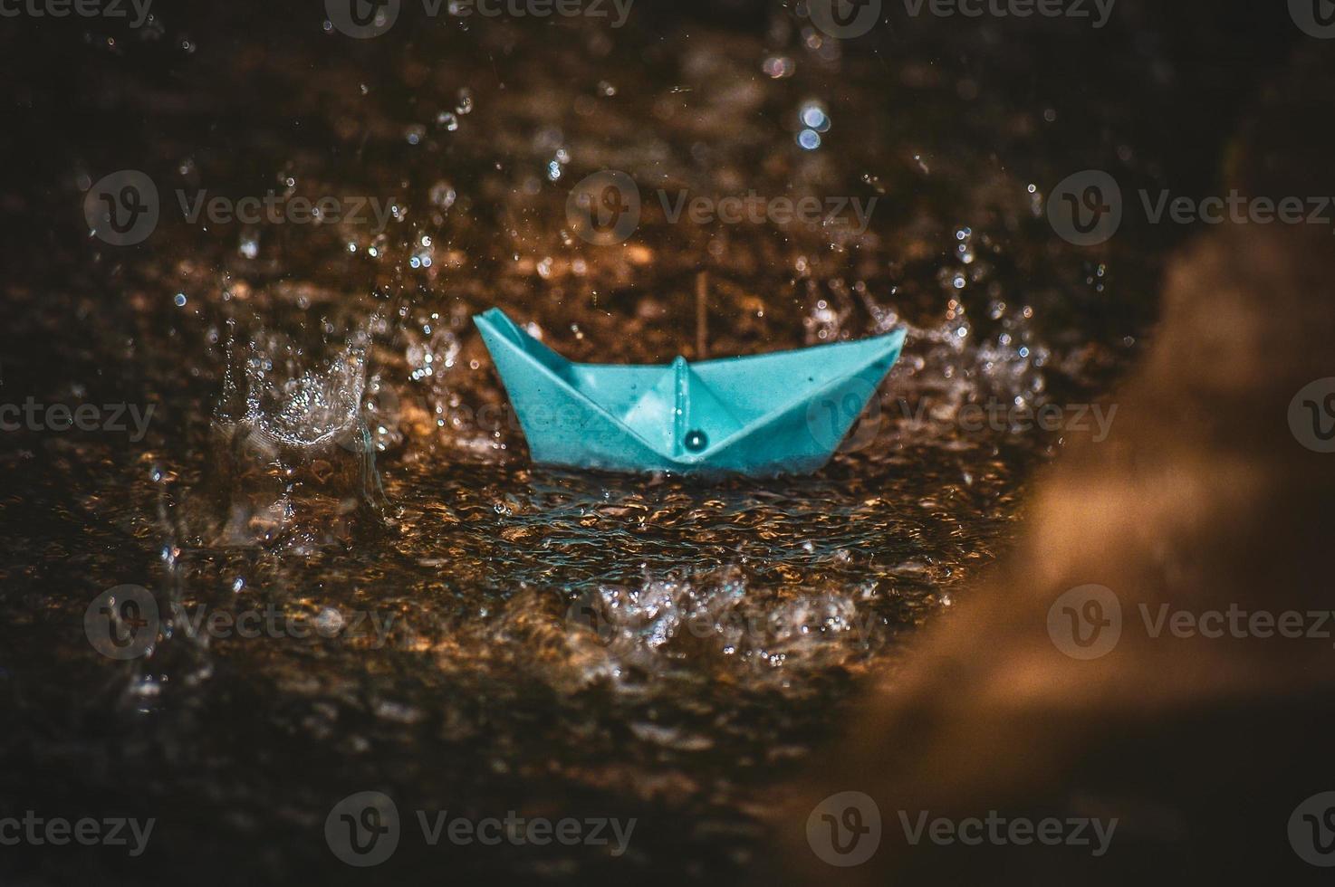 Origami paper boat in the rain photo