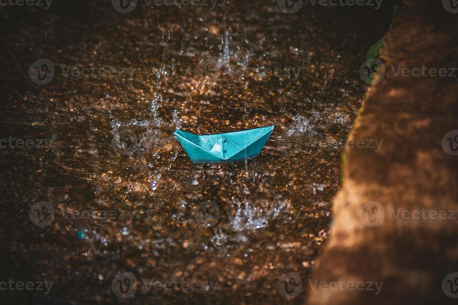 Origami paper boat in the rain photo