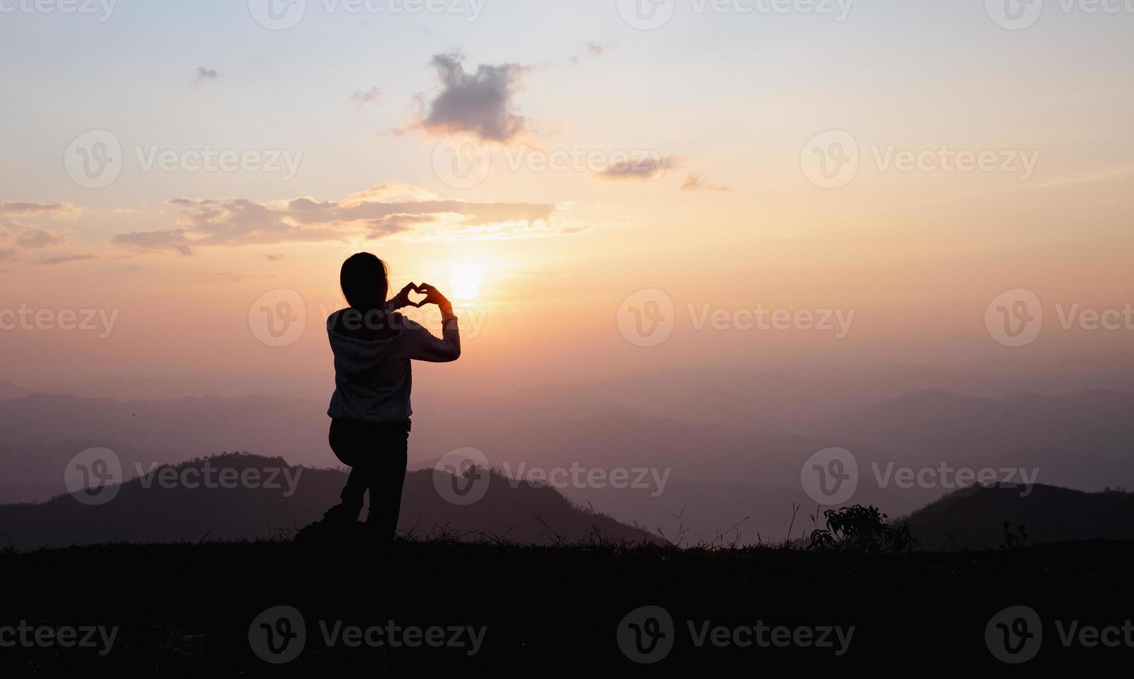 Hands in shape of love heart, Female hands in the form of heart against the sky pass sun beams. Happy  in love. photo