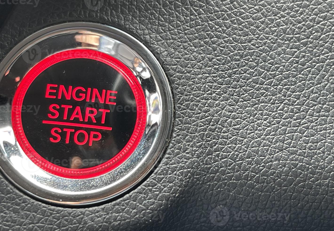car engine start stop button on dark leather background. copy space photo